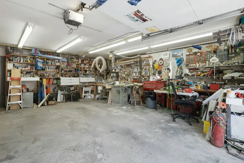 Garage filled with shelves, tools, and stored belongings